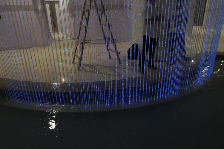 在光纖水簾區域澆筑混凝土基礎平臺，在平臺上固定型鋼結構，在鋼結構上安裝音樂噴泉設備